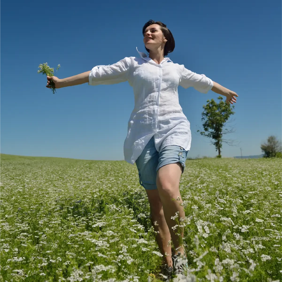 Woman joyously walking through a field